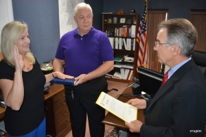 City Manager Joseph Scherer holds the Bible as Doughtie administers the oath of office to Storey.