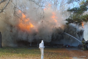 A firefighter puts water on the blaze.