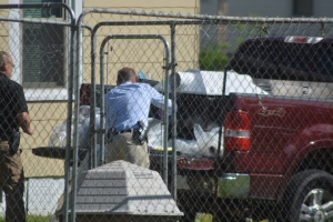 Investigators load items into a pickup Tuesday.