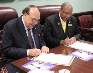 Perkins, left, and Griffin sign the agreements.