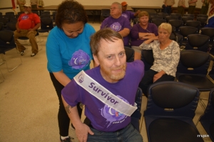 A survivor is helped with his sash.