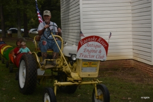 A tractor pulling cars for children and adults makes its way around the 4H Rural Life Center.