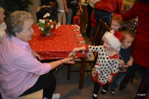 A child hands a resident a bag of cookies.