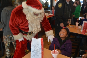A child laughs with Santa during breakfast at Chick-fil-A before the Walmart shopping spree.