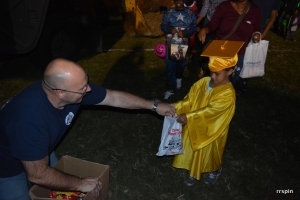 Roanoke Rapids police Chief Chuck Hasty hands out candy to a child dressed as a graduate this evening.