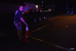 Hasty rearranges crime scene tape to allow the city fire department better access to illuminate the area.
