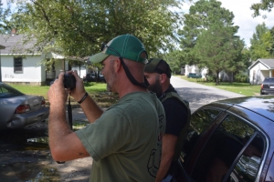 Hardy, left, takes a photo of the scene as Babb observes.